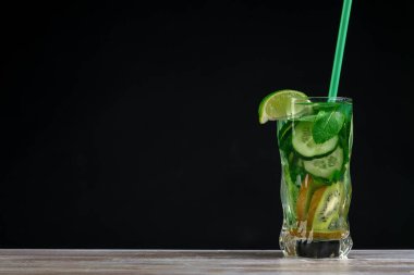 Citrus meyvesi ve otlar, tahtadan yapılmış cam şişelerde arınma veya diyet için sassi suyu, koyu arka plan, seçici odak, kare mahsul. Temiz yemek, kilo kaybı, sağlıklı yaşam tarzı konsepti.