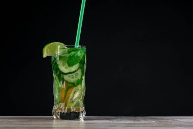 Citrus meyvesi ve otlar, tahtadan yapılmış cam şişelerde arınma veya diyet için sassi suyu, koyu arka plan, seçici odak, kare mahsul. Temiz yemek, kilo kaybı, sağlıklı yaşam tarzı konsepti.