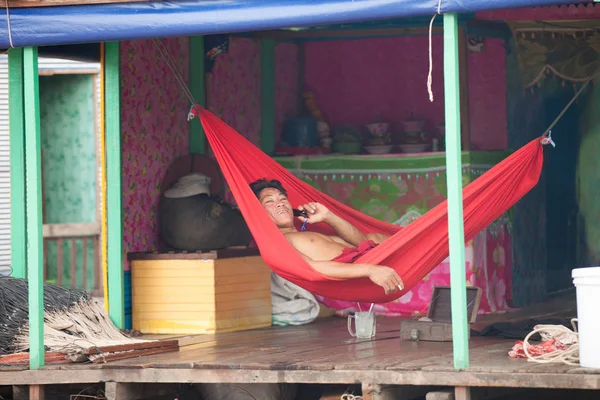 Hayat Tonle Sap Gölü. Bir adam cep telefonundan konuşuyor. Kamboçya. 31 Temmuz 2012