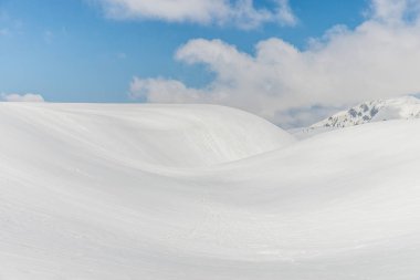 Snow hills against clear blue sky 