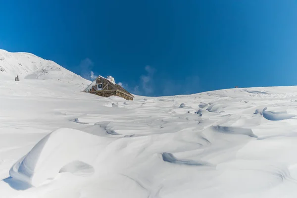 Holzhütte in verschneiter Landschaft — Stockfoto