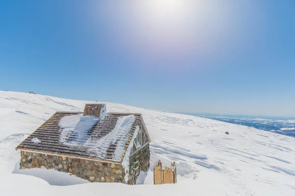 Dřevěná chata v zasněžené krajině — Stock fotografie