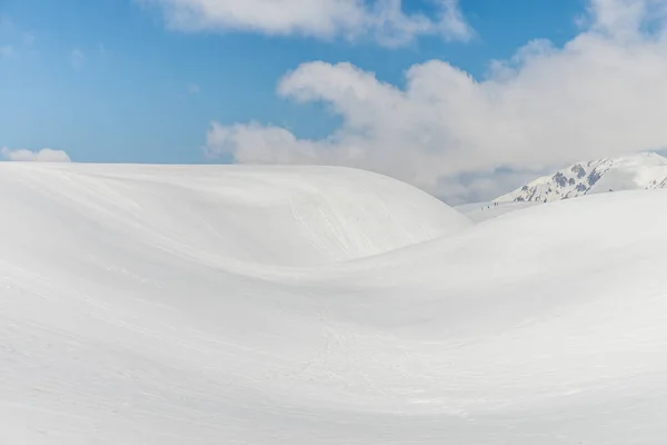 Snö kullar mot klar blå himmel — Stockfoto
