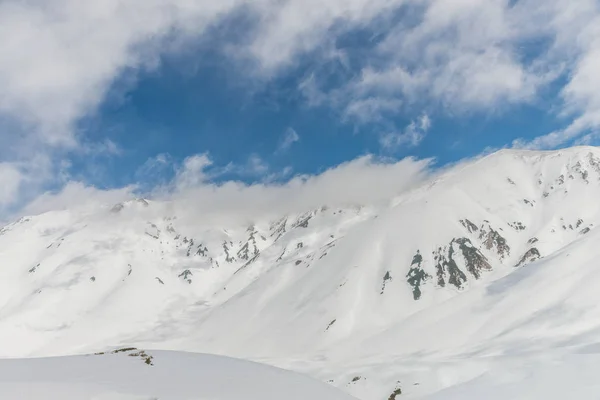 Höga berg under snö med klar blå himmel — Stockfoto