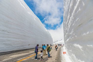 Tourists walk along snow corridor on clipart