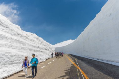 Tourists walk along snow corridor on clipart