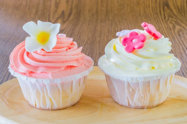 Sabrosos cupcakes en plato de madera —  Fotos de Stock