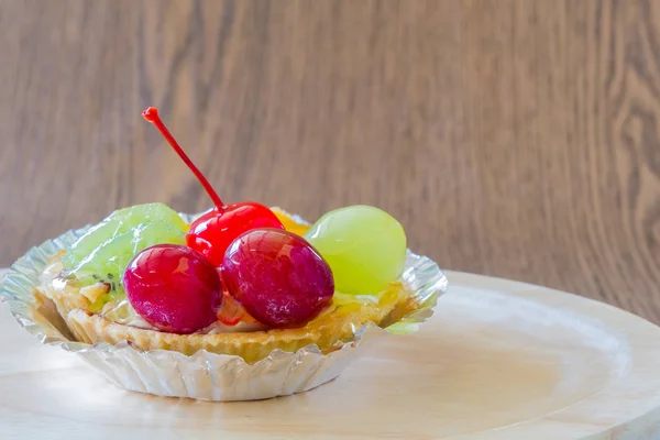 Fruit tarts on wood plate — Stock Photo, Image