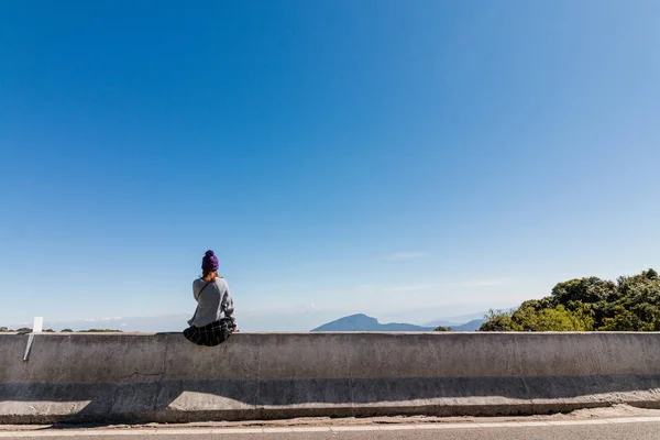 Den unga kvinnan sitter och tittar på naturen med känna sig ensam — Stockfoto