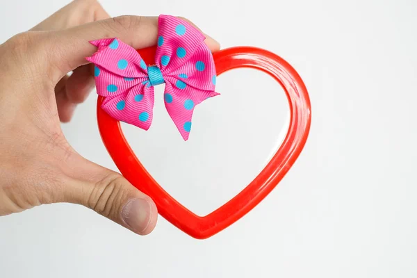 Hand of a young man holding a red heart shaped on white background — Stock Photo, Image