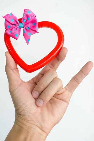 Hand of a young man holding a red heart shaped on white backgrou — Stock Photo, Image