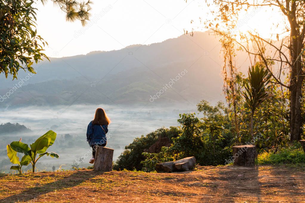 Young woman watching sunrise high in the mountain at Phu Lung ka