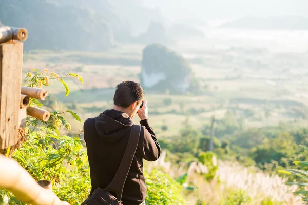 Mladý muž fotografování východ slunce v horách na Phu plic ka, Thajsko — Stock fotografie