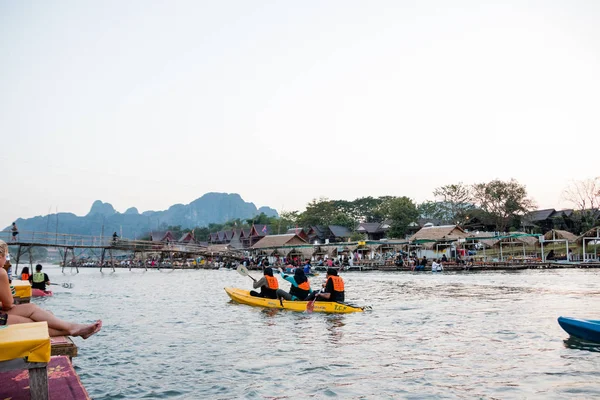 Vangviang, Laos - 18 de fevereiro: Turistas não identificados estão remando barcos de caiaque em Song River em 18 de fevereiro de 2017 em Vangviang, Laos — Fotografia de Stock