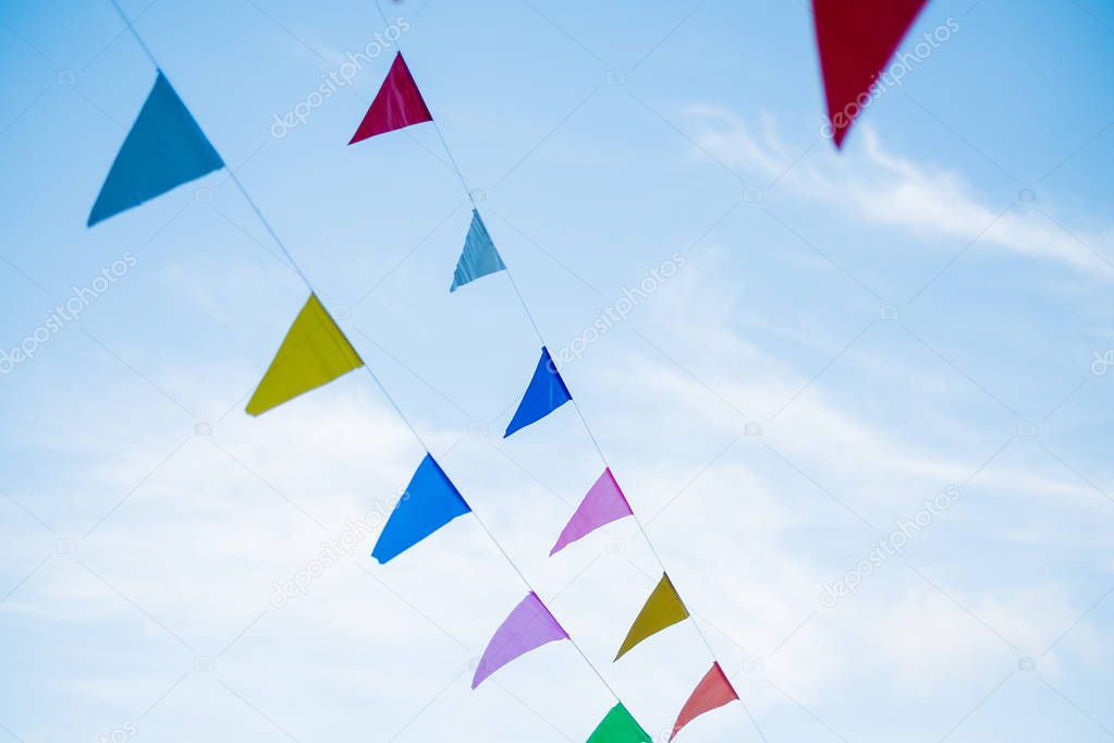 festival flag line with blue sky in background