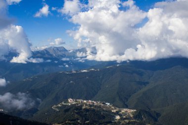Güneş ışığıyla bir dağ manzarasının tepesinde boş duruyor