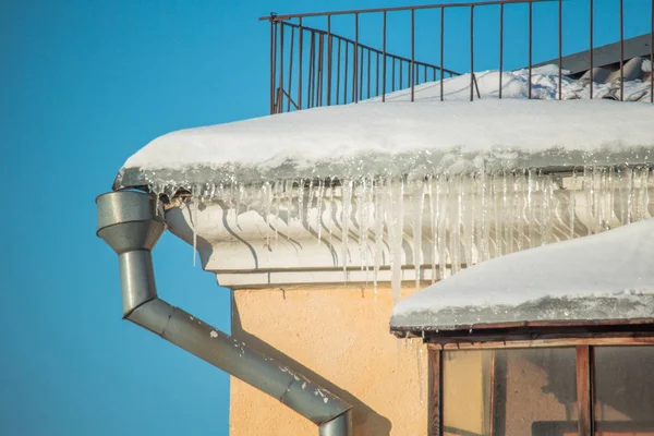 Dangerous icicles in a house roof — Stock Photo, Image