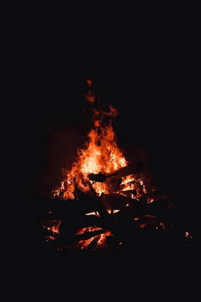 Fogueira queimando árvores à noite. Fogueira acesa brilhantemente, calor, luz, acampamento, fogueira grande . — Fotografia de Stock
