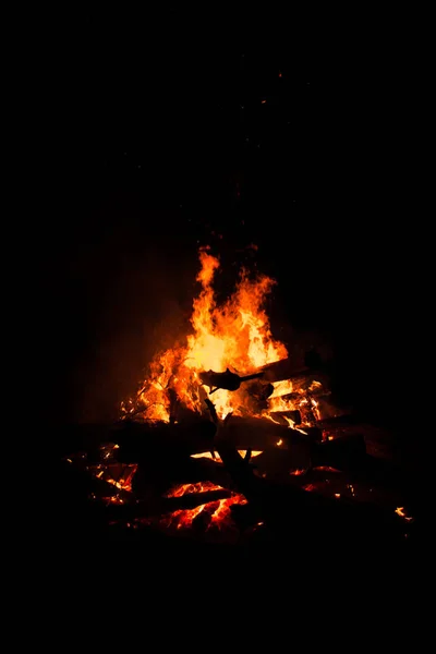 Fogueira queimando árvores à noite. Fogueira acesa brilhantemente, calor, luz, acampamento, fogueira grande . — Fotografia de Stock