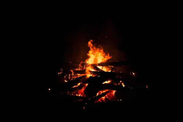 Fogueira queimando árvores à noite. Fogueira acesa brilhantemente, calor, luz, acampamento, fogueira grande . — Fotografia de Stock