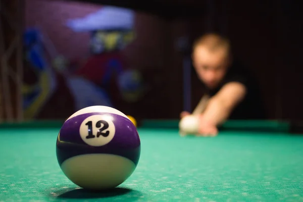 Joven jugando billar en el club de billar oscuro . —  Fotos de Stock