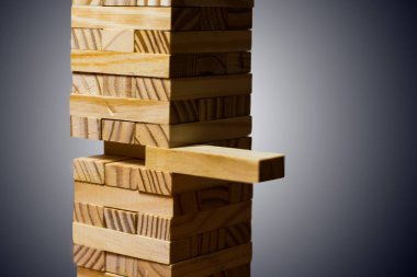 Closeup tahta bloklar, koyu tonu kuleden bir blok almak.