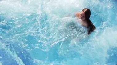 Genç güzel kız sıcak küvet havuzunda yüzüyor