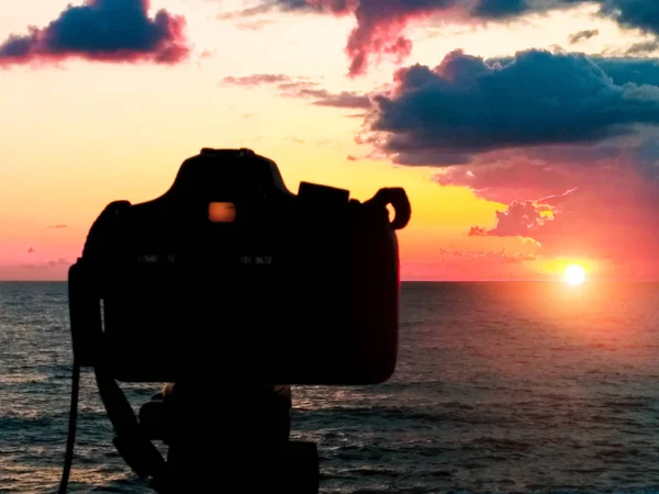 Câmera Dslr fotografando colinas da Toscana. Câmera Dslr atirando em um pôr do sol de paisagem urbana com reflexão do mar — Fotografia de Stock