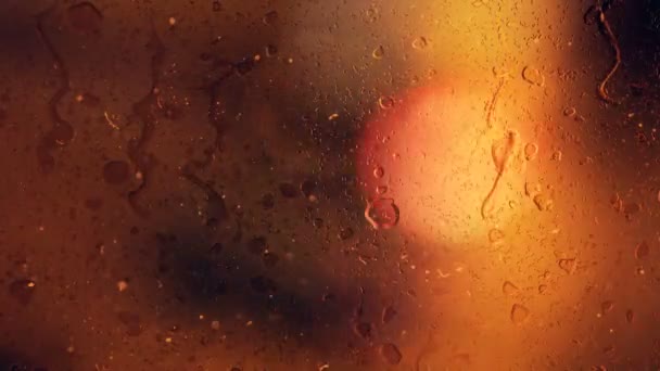 Des gouttes de pluie coulent dans le verre sur le fond bokeh des voitures en mouvement — Video