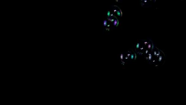 Colorful soap bubbles in slow motion on a black background — Stock Video