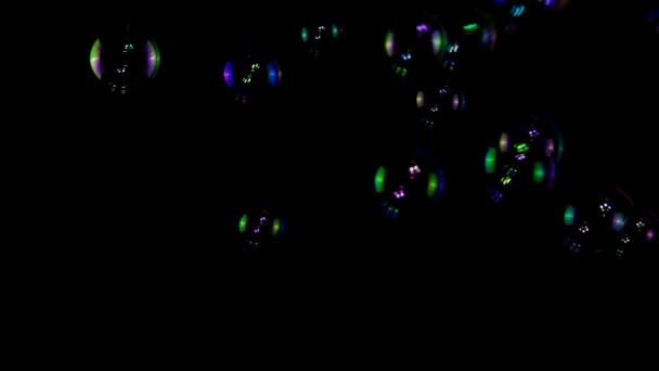 Bulles de savon colorées au ralenti sur fond noir 