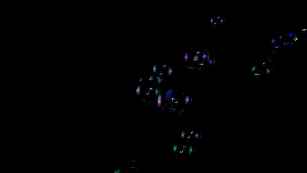 Bulles de savon colorées au ralenti sur fond noir 