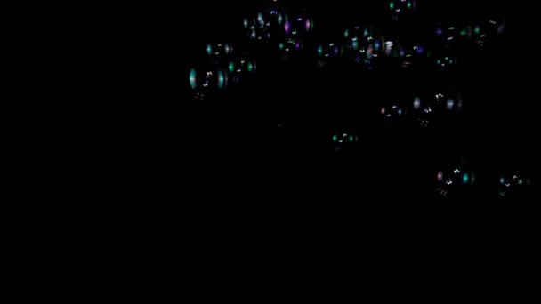Bulles de savon colorées au ralenti sur fond noir 