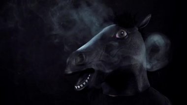 Bir at duman siyah bir arka plan ağır çekimde maskeli adam
