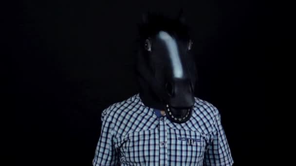 Человек в маске лошади кивает головой танцуя изолированно на черном фоне замедленного движения — стоковое видео