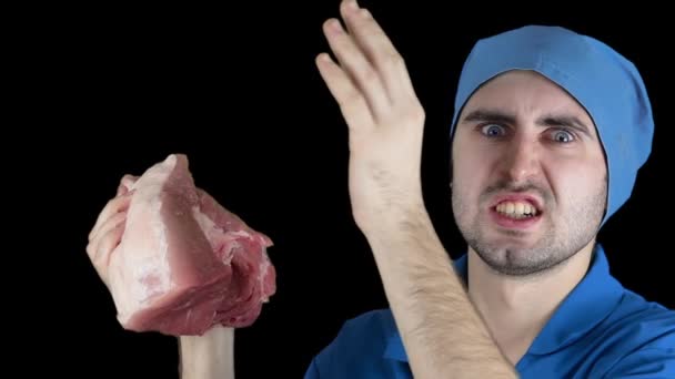 An angry bearded doctor slaps a piece of meat in slow motion — Stock Video