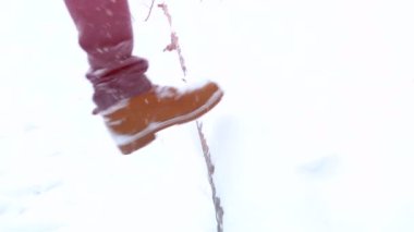 Ağır çekimde kar düşen engellerin üstesinden çizme bir kış manzarası, dağlar, kış yürüyüş yürüyüş ayaklarda