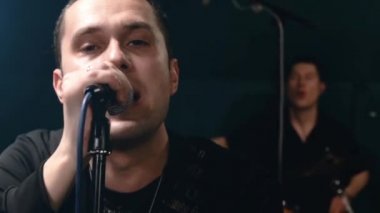Rock grubu solisti, gitarist ve davulcu provası. Müzik punk, ağır metal veya rock grubu.