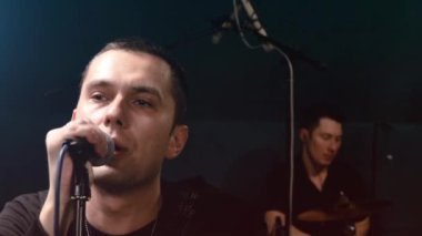 Rock grubu solisti, gitarist ve davulcu provası. Müzik punk, ağır metal veya rock grubu.