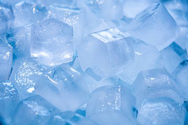 Beyaz bir arka plan üzerinde yavaş çekimde eriyen berrak sudan buz küplerinin makro çekimi. Konsept: saf dağ kaynak suyu, buz, kokteyller, taze ve dondurulmuş gıdalar.