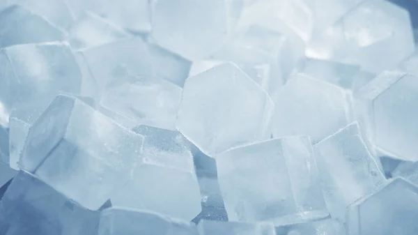 Macro de cubos de hielo de agua clara que se derriten en cámara lenta sobre un fondo blanco. Concepto: agua pura de manantial de montaña, hielo, cócteles, alimentos frescos y congelados . —  Fotos de Stock