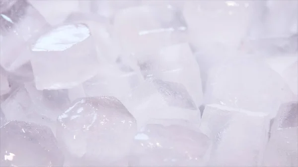 Macro de cubos de hielo de agua clara que se derriten en cámara lenta sobre un fondo blanco. Concepto: agua pura de manantial de montaña, hielo, cócteles, alimentos frescos y congelados . — Foto de Stock