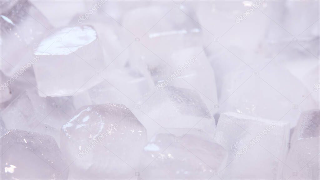 Macro shot of ice cubes from clear water that melt in slow motion on a white background. Concept: pure mountain spring water, ice, cocktails, fresh and frozen foods.