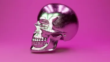 A scratched metal human skull rotates 360 degrees against a glamorous pink background. Seamless loop 3d render