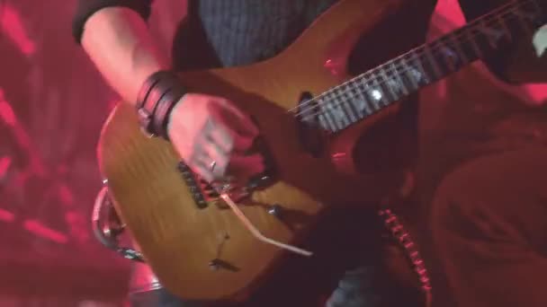 Un guitariste virtuose jouant une guitare électrique sur scène avec des lumières LED clignotantes . — Video