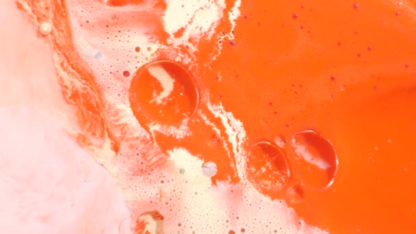 Tintas acrílicas coloridas misturam-se em belos padrões. Tintas de óleo de coral, laranja, vermelho e outras cores espalhadas pela superfície e misturar, criando texturas incríveis e design. Bolhas abstratas — Vídeo de Stock