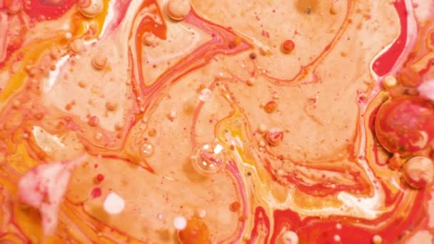 カラフルなアクリル絵具は美しいパターンでミックスします。石油サンゴ、オレンジ、赤や他の色のインクが表面に広がり、混合し、素晴らしいテクスチャとデザインを作成します。概要泡 — ストック動画