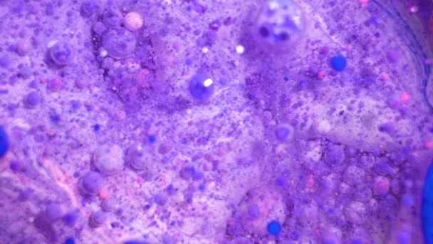 Peintures pétillantes colorées se mélangent dans de beaux motifs. L'encre à l'huile de bleu et d'autres couleurs se répandent sur la surface et se mélangent pour créer des textures et un design étonnants .