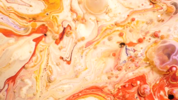 Coloridas pinturas acrílicas se mezclan en hermosos patrones. Tintas de aceite de coral, naranja, rojo y otros colores se extienden por la superficie y se mezclan, creando texturas y diseños increíbles. Burbujas resumidas — Vídeo de stock