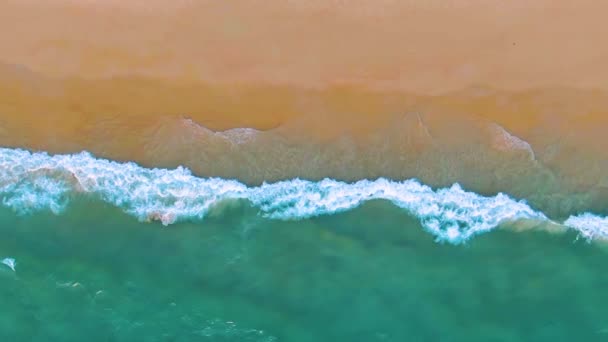 熱帯の砂浜リゾートビーチのトップビュー。ゆっくりとした動きで海の波。空中4kビュー — ストック動画